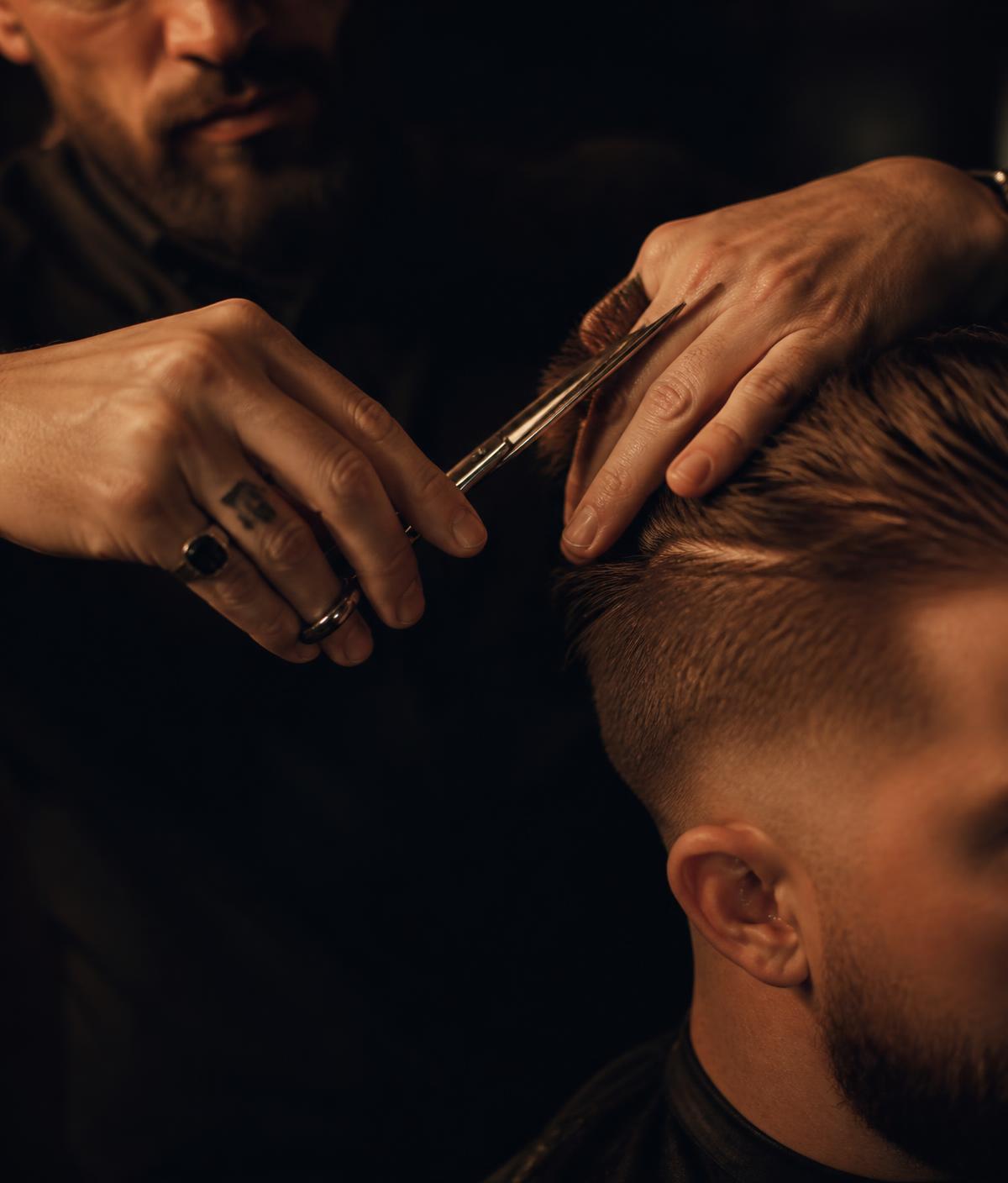 Barber cutting a client's hair with scissors at Kings Barbershop